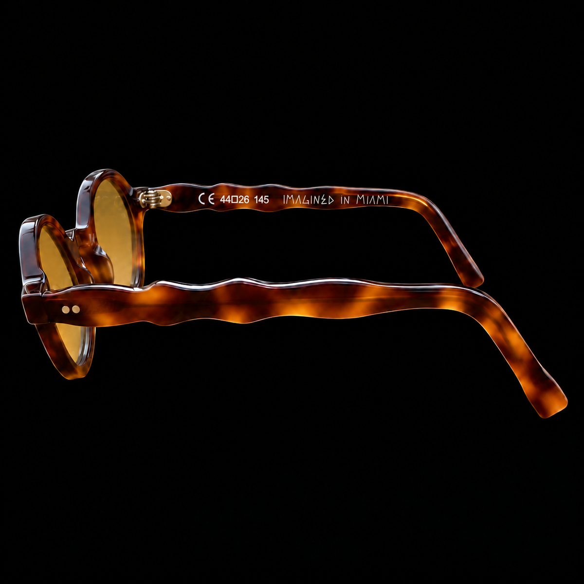 MARCEL Scholar Study 06220 brown tortoiseshell sunglasses with amber lenses, side view on black.