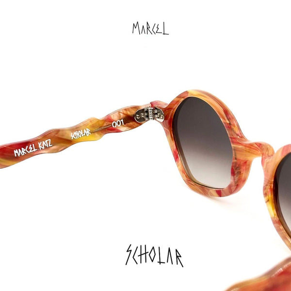 Sunglasses with tortoiseshell frame and dark lenses on a white background, featuring the brand 'Marcel Katz'. 3/4 back view.