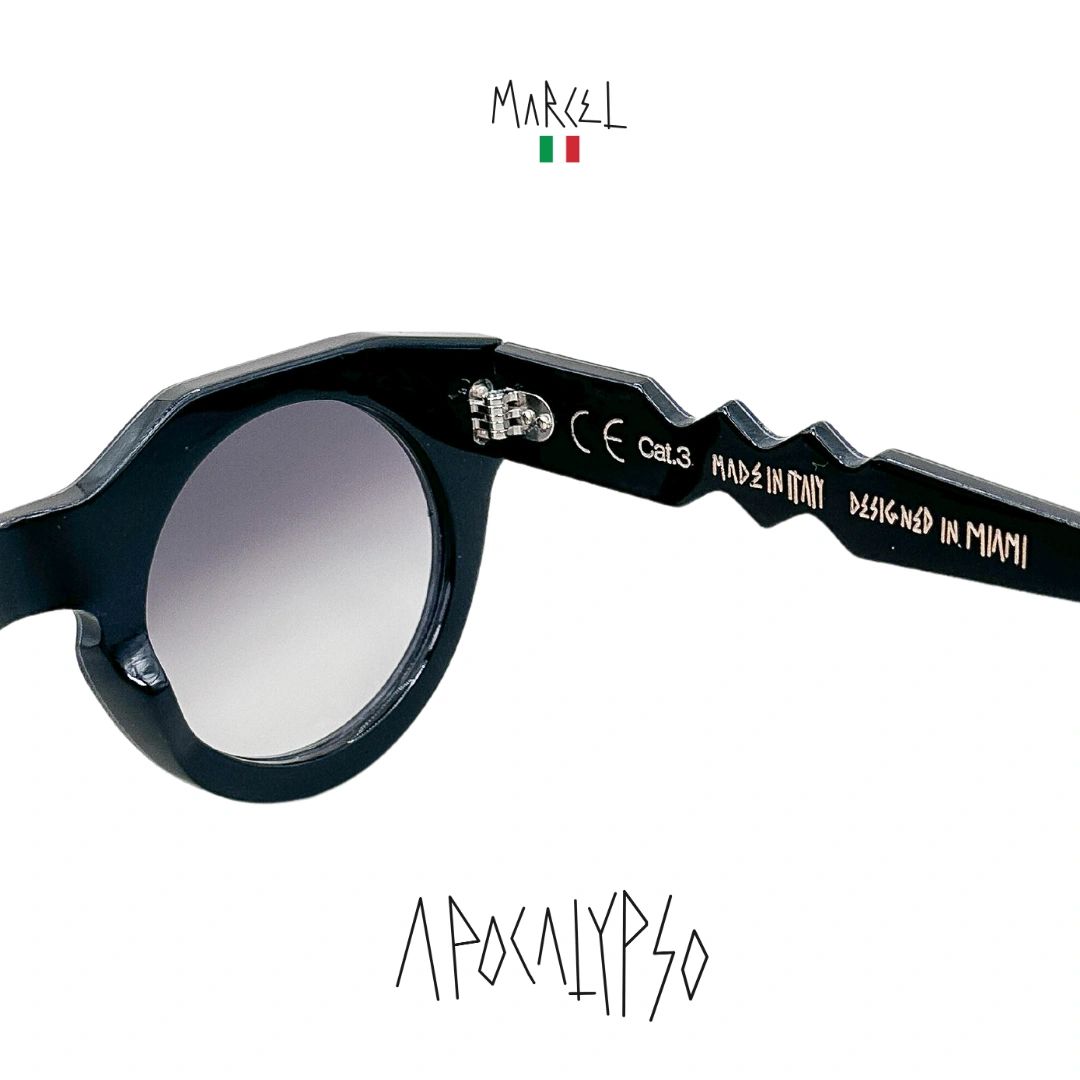 Black sunglasses with 'Marcel' branding on a white background. Close up of temple engraving.