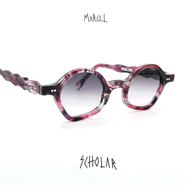 Pink and black sunglasses with 'Marcel' branding on a white background. 3/4 front view.