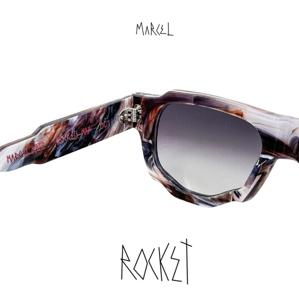 Sunglasses with a unique frame design on a white background, featuring the brand 'Marcel'. Close-up of temple engraving.
