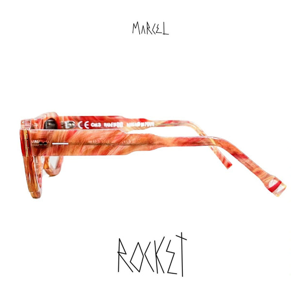 Sunglasses with a red and orange pattern on a white background, featuring the brand 'Marcel'. Profile view.
