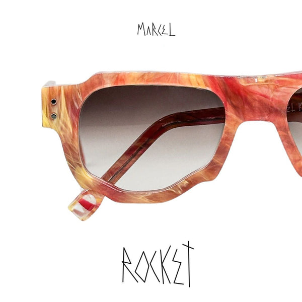 Sunglasses with a marbled design on a white background, featuring the brand 'Marcel'. Close-up of lenses.