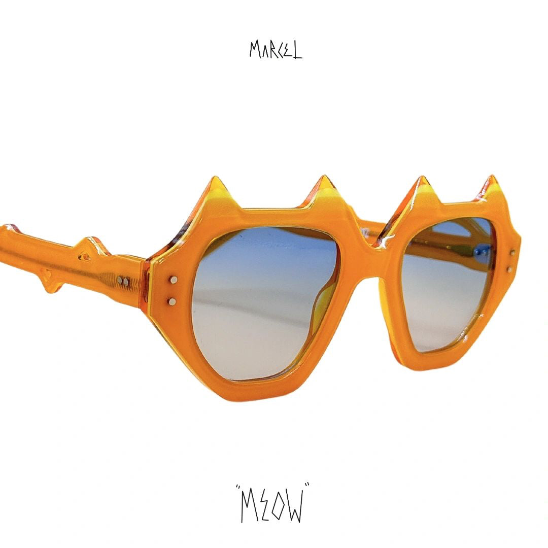 Orange sunglasses with spike-like design on a white background, featuring the brand 'Marcel' and 'Meow'. 3/4 view.