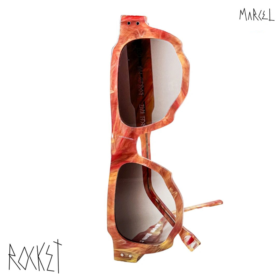 Sunglasses with a tortoiseshell pattern on a white background, featuring the brand 'Marcel'. Front view.
