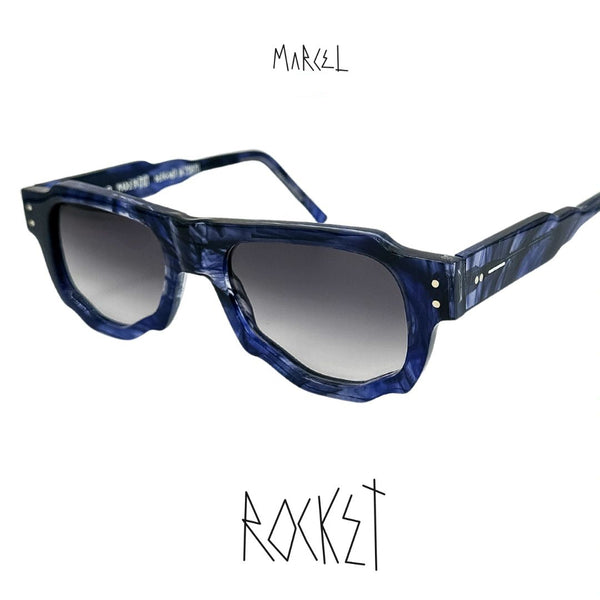 Blue sunglasses with gradient lenses on a white background, featuring the brand 'Marcel'. 3/4 view.