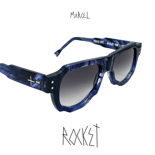 Blue sunglasses with a white background, featuring the brand 'Marcel' and model 'Rocket'. 3/4 front view.