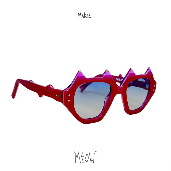 Red sunglasses with spike-like design on a white background, featuring the brand 'Marcel' and 'Meow.' 3/4 front view.