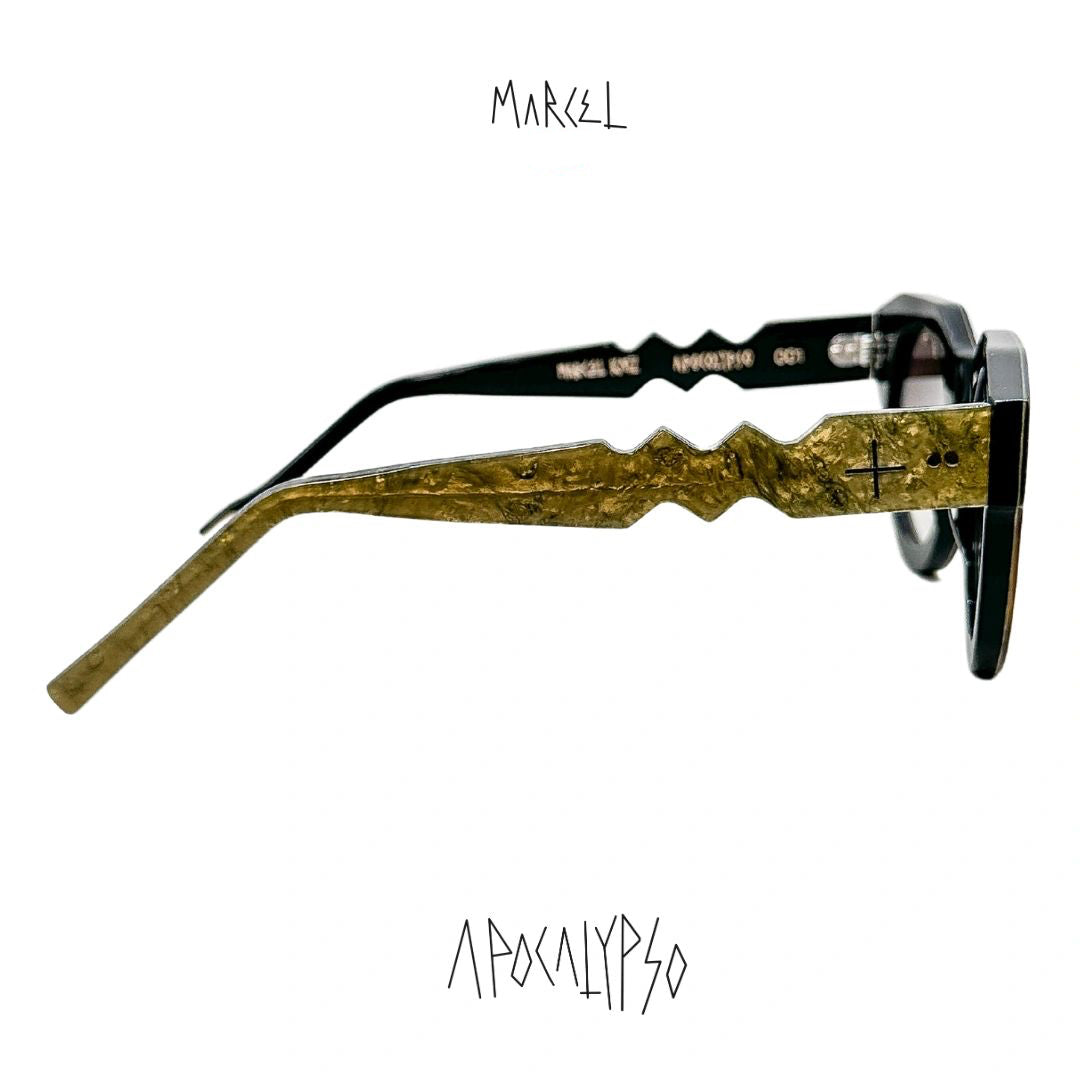 Sunglasses with gold and black design on a white background, featuring the brand 'Marcel'. Profile view.