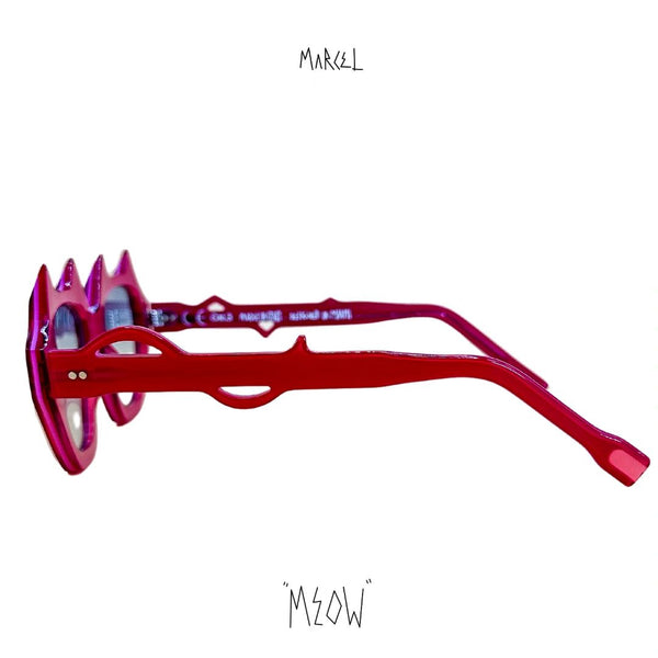 Red and pink sunglasses with spike-like design on a white background, featuring the brand 'Marcel' and 'Meow'. Profile view.
