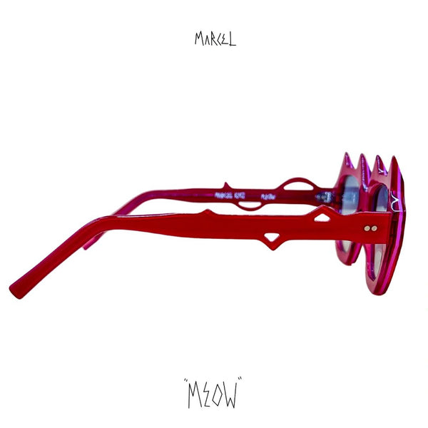 Red sunglasses with a unique design on a white background, featuring the brand 'Marcel' and 'Meow'. Profile view.